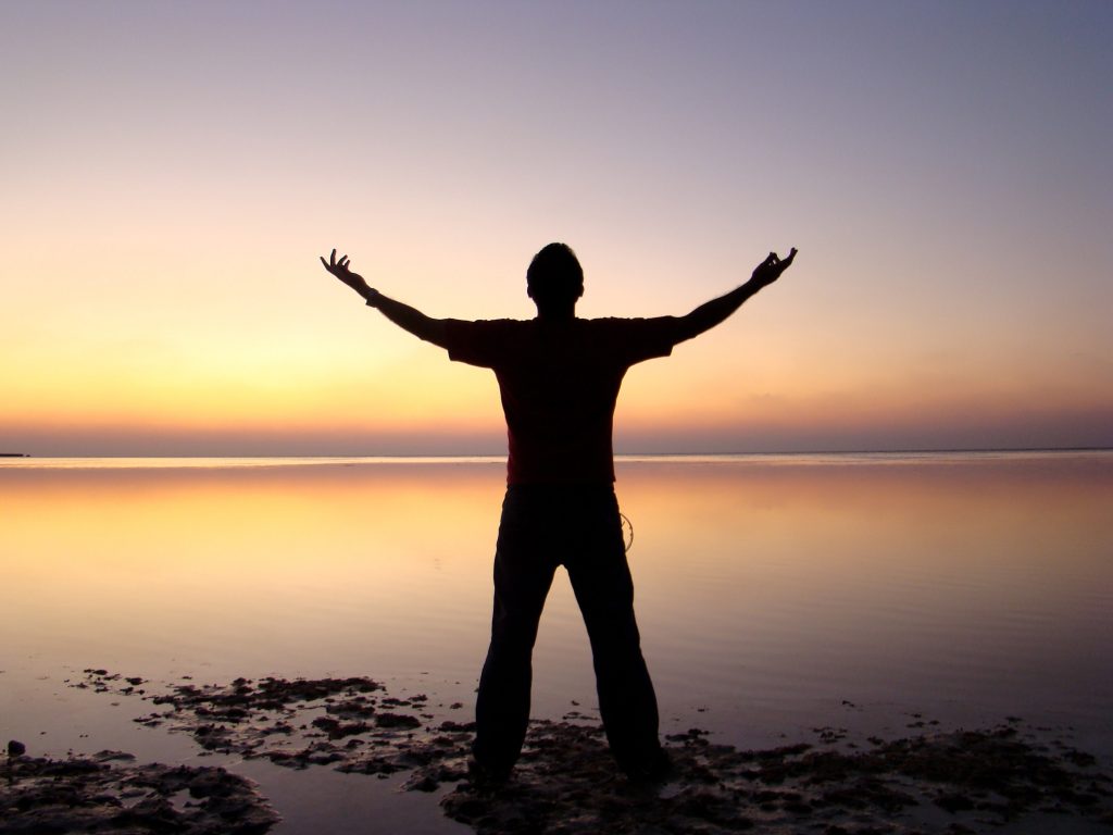 man celebrating success at sunset