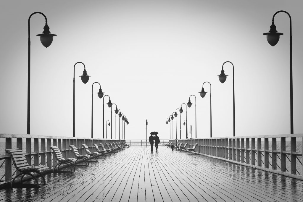people walking on a pier in the rain on a date